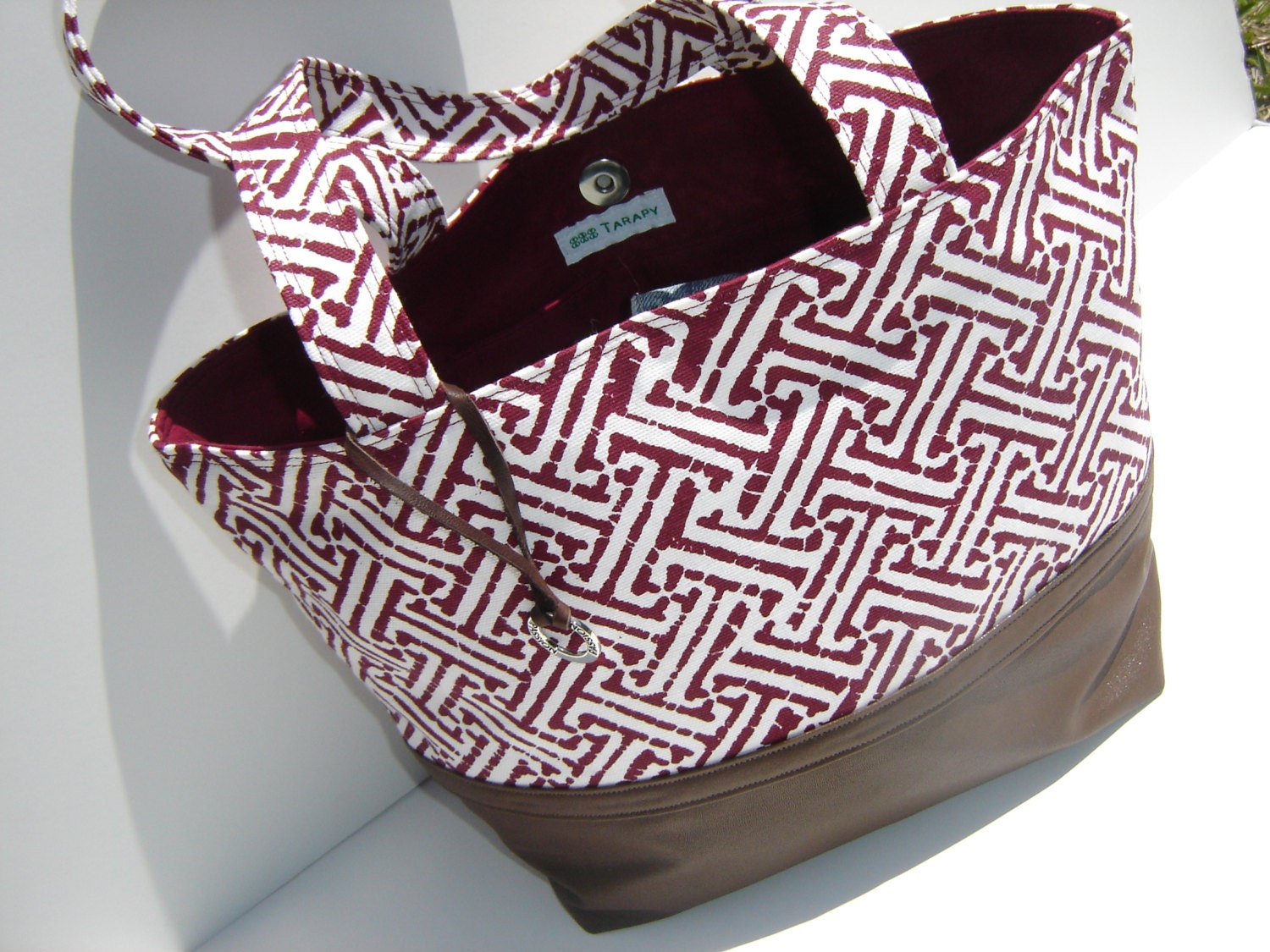 Dark red and white canvas geometric print medium handbag with faux leather (vinyl) bottom