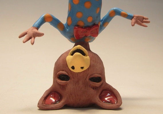 Upside down bird boy waiving his arms and smiling.