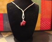 Red beads on white string necklace