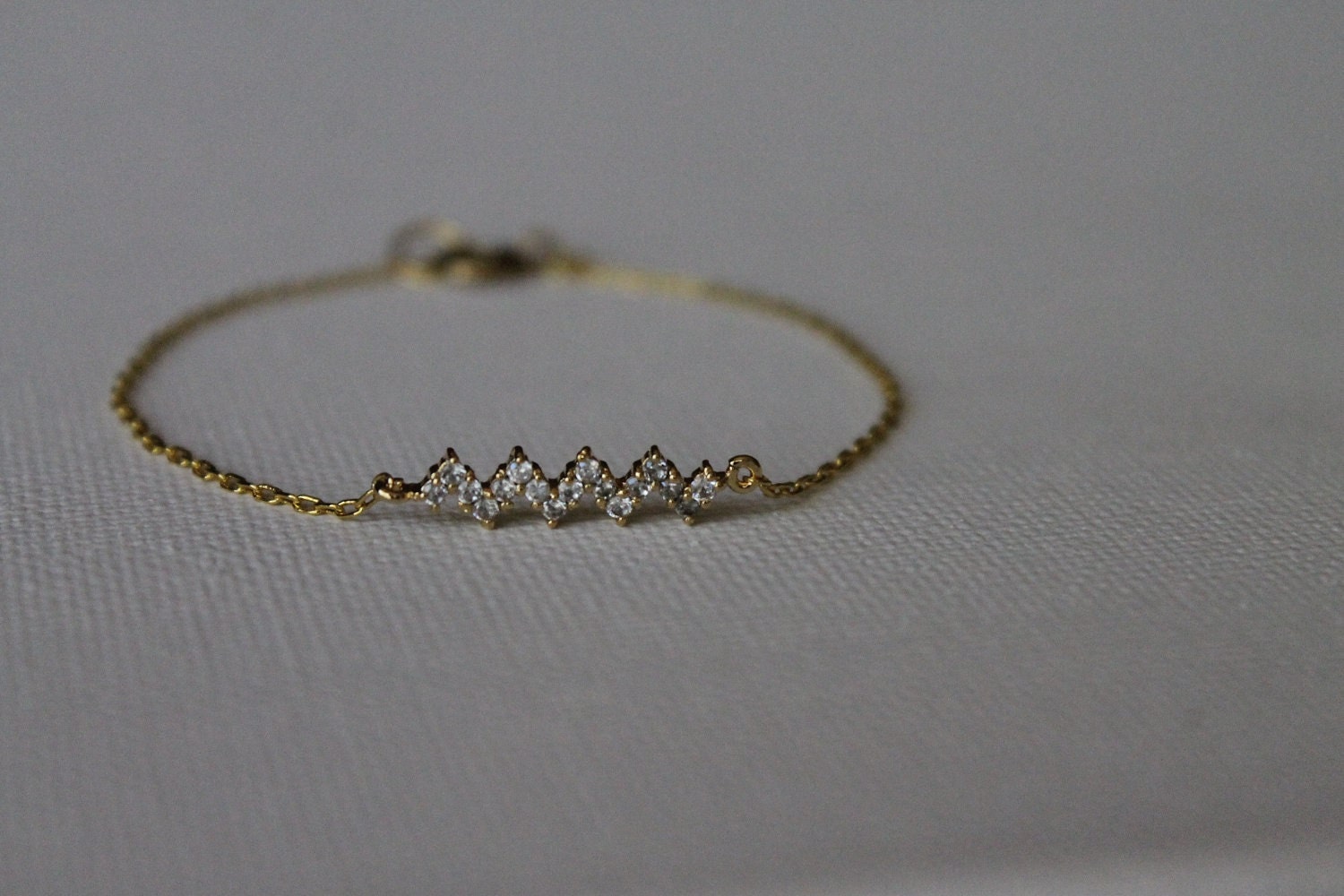 delicate gold chain bracelet featuring a clear crystal rhinestone zigzag chevron charm