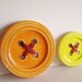 Orange ceramic button sculpture, stoneware clay, orange button wall hanging with dark orange yarn