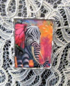 A colorful elephant, reversible, glass encased, lead-free soldered pendant.  Chain included.