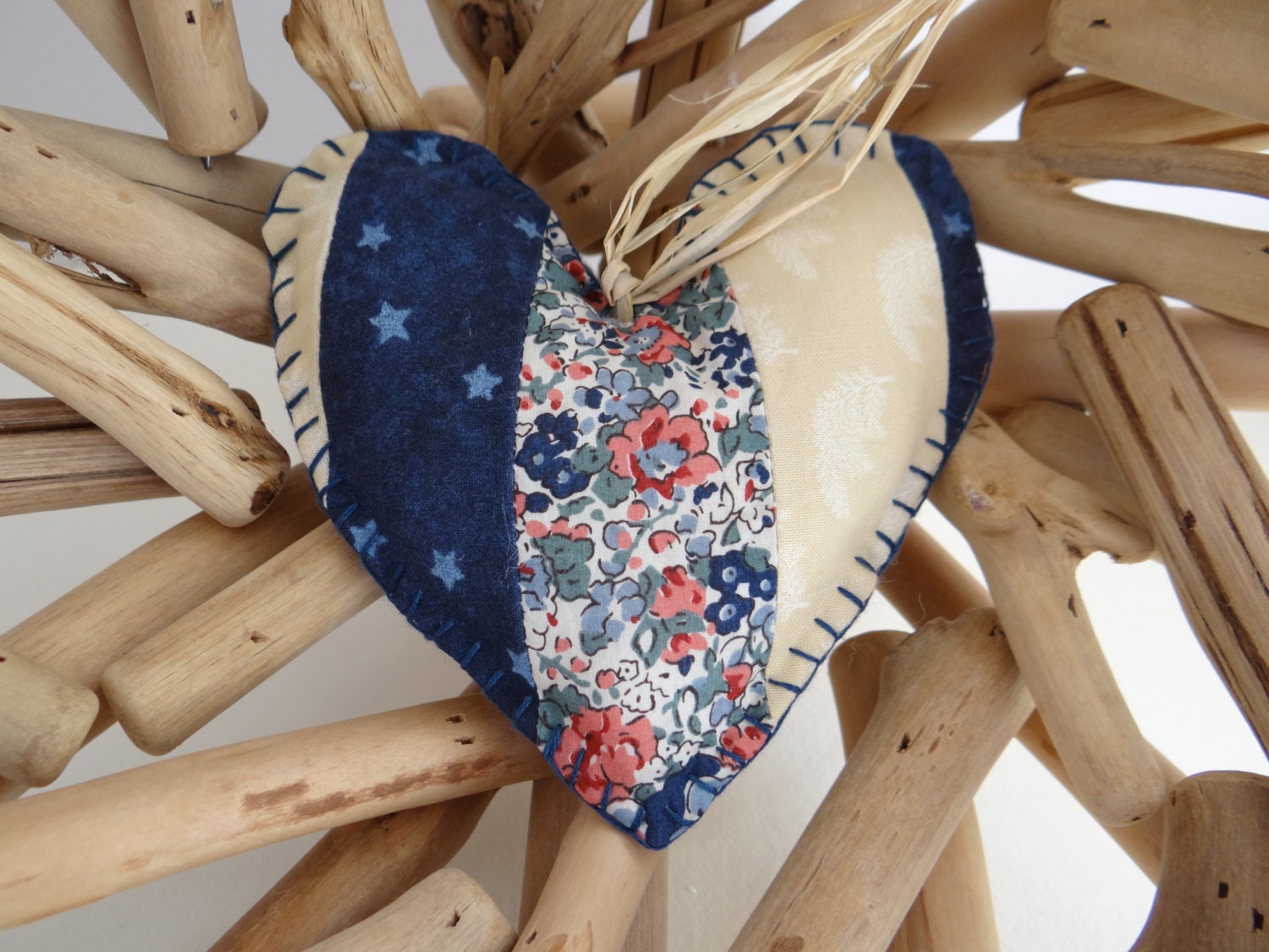 A handmade patchwork shaped heart ornament in blue and cream