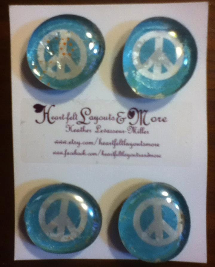 set of four glass magnets with blue and white peace signs.