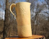 Tall handbuilt pitcher in yellow