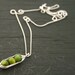 Three peas in a pod, green mother of pearl peapod pendant necklace on sterling silver chain.