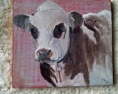 Spotted cow on wood