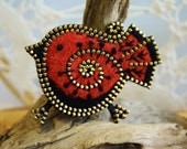 Rusty orange and black bird brooch