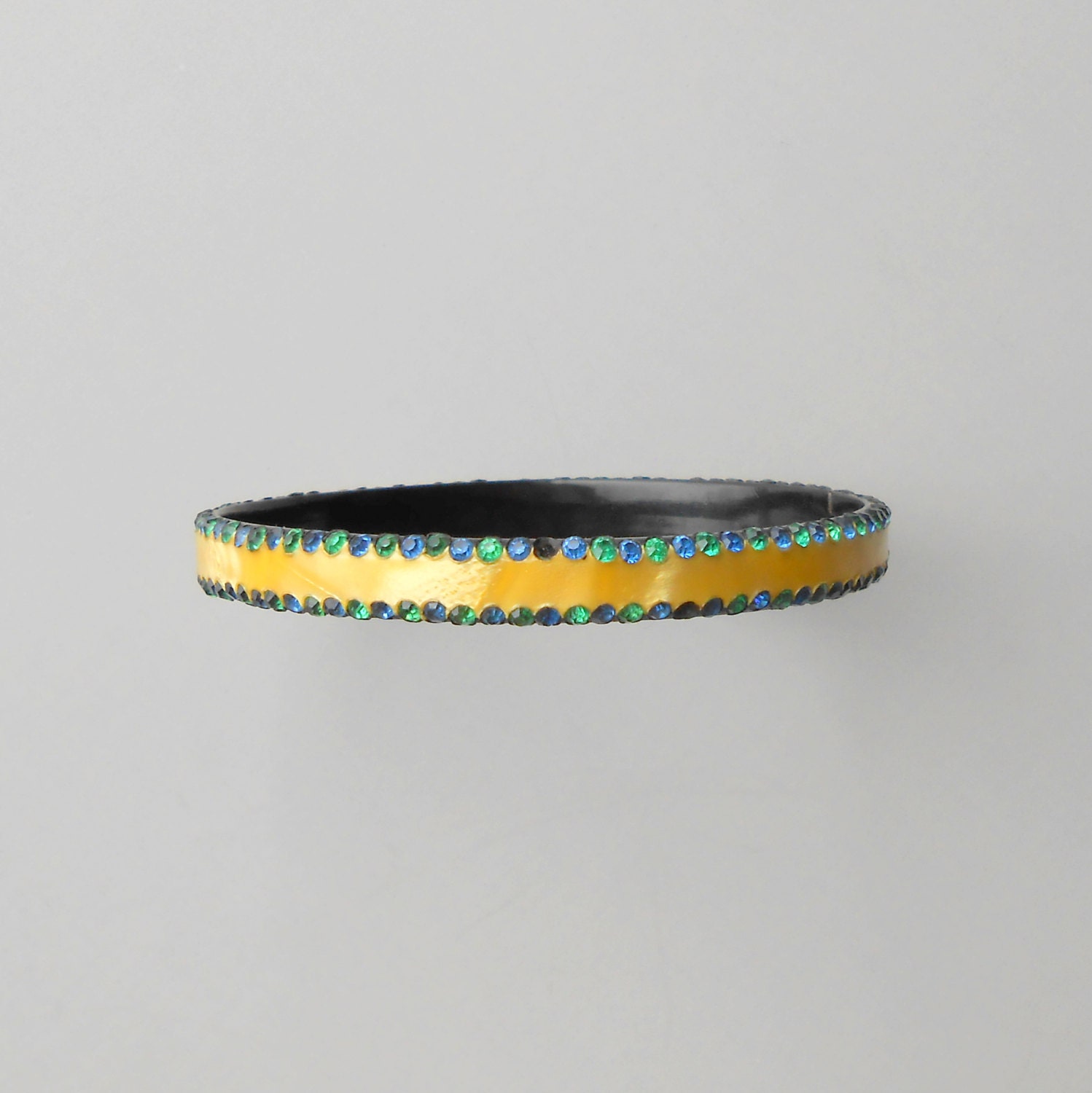 Art Deco Celluloid Bangle with Rhinestones. Satiny Yellow with Blue & Green. Black Background. Bracelet.