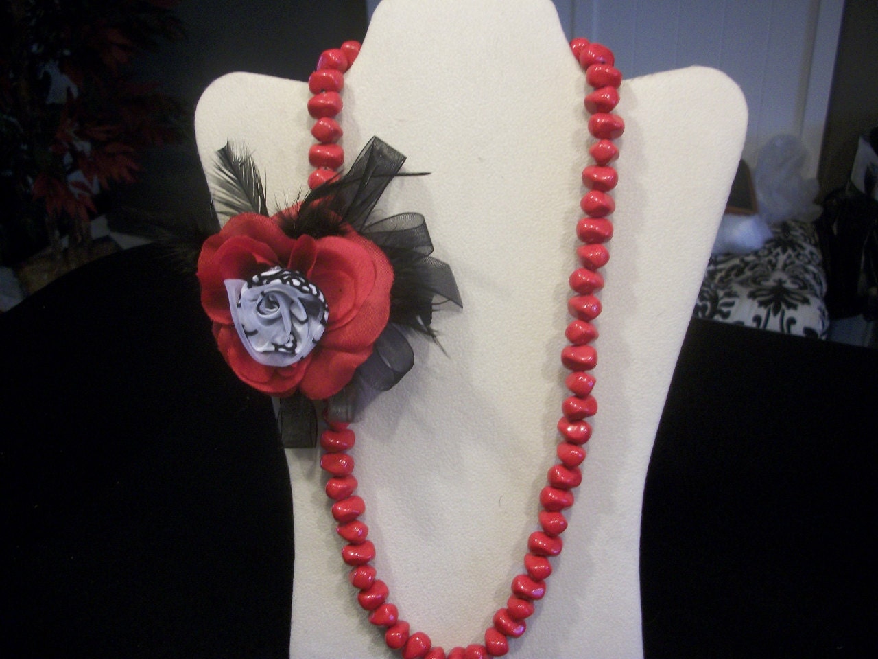 Long red beaded necklace with side feathered rosette fun fancy