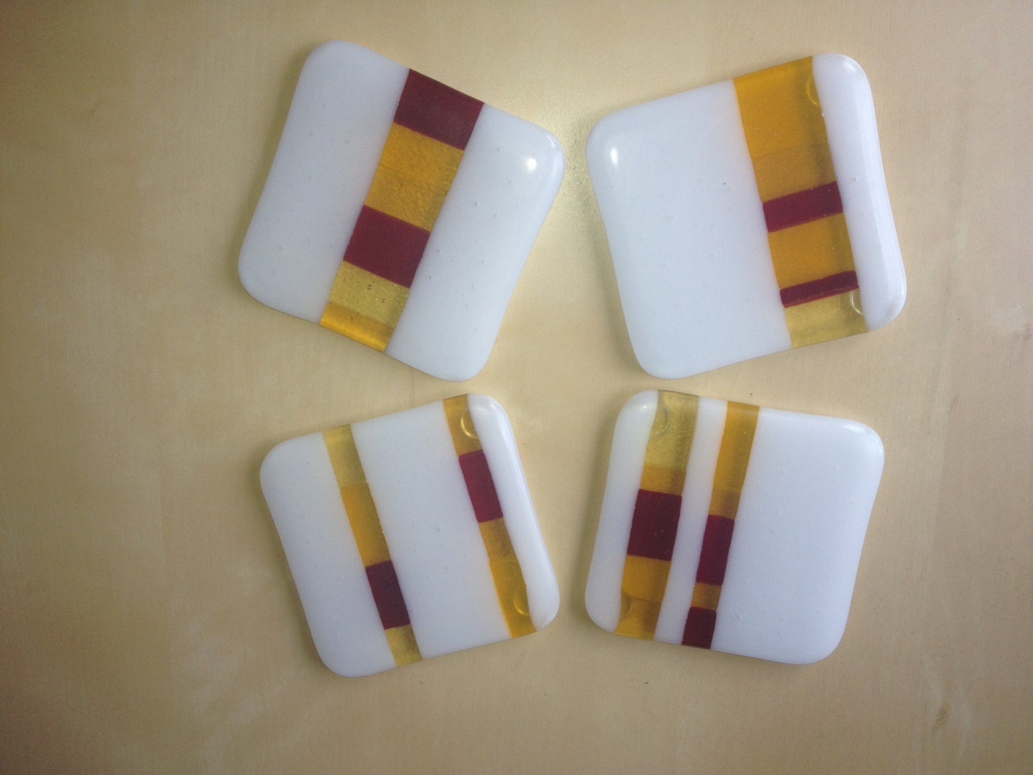 A set of 4 fused glass coasters in red and amber