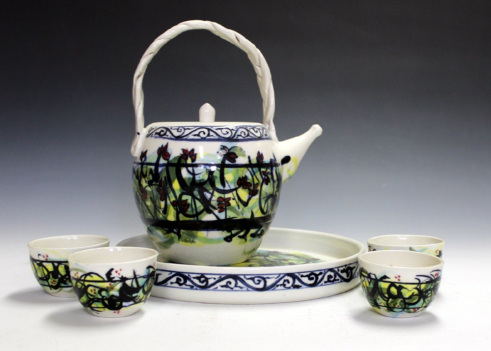 Ceramic pottery and porcelain tea set with four matching tea bowls and tray