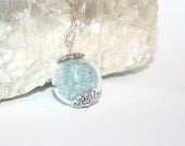 Aquamarine gemstones  in a  Clear Glass Orb Necklace, silver chain