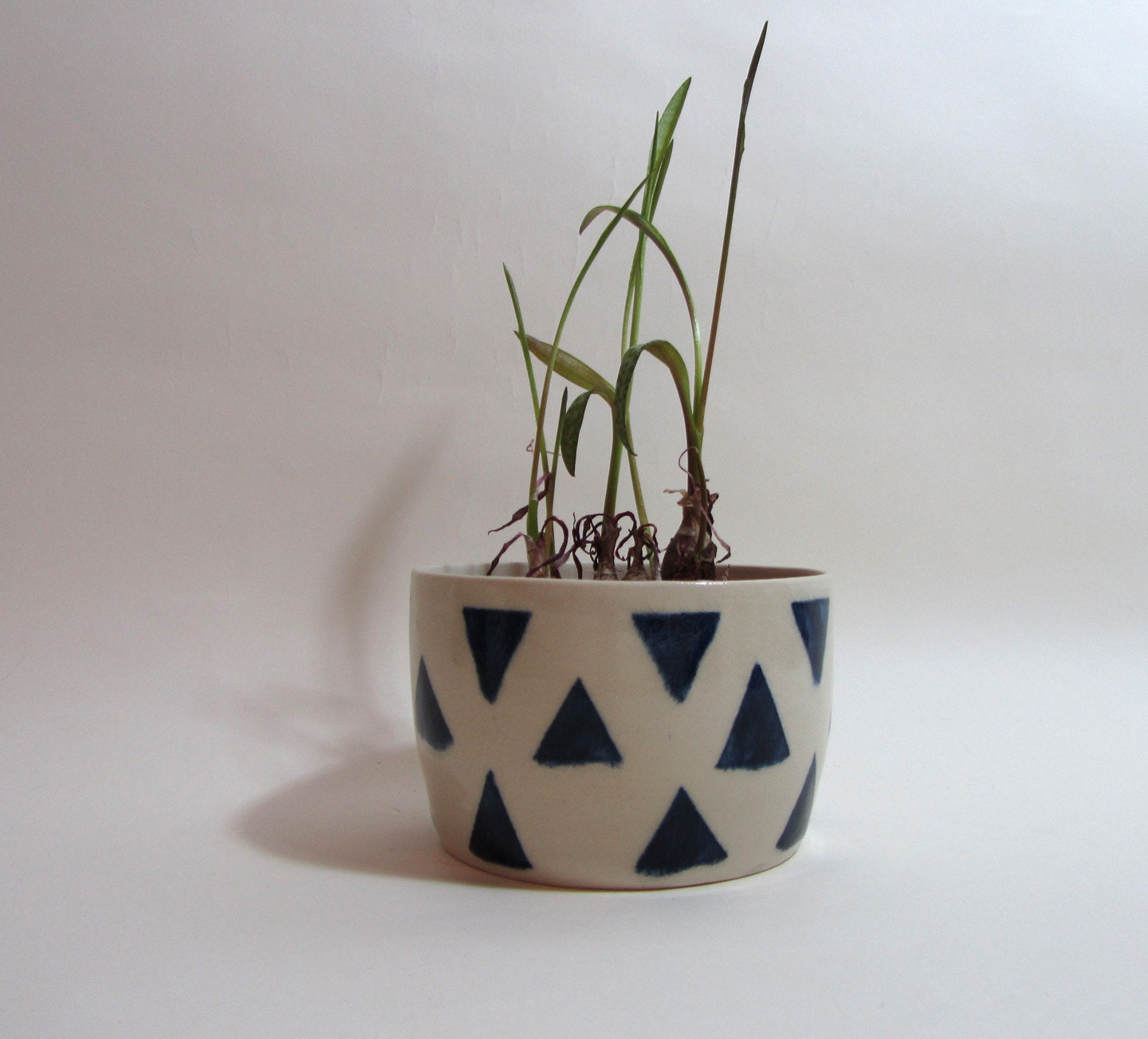 White planter with dark blue pattern of triangles