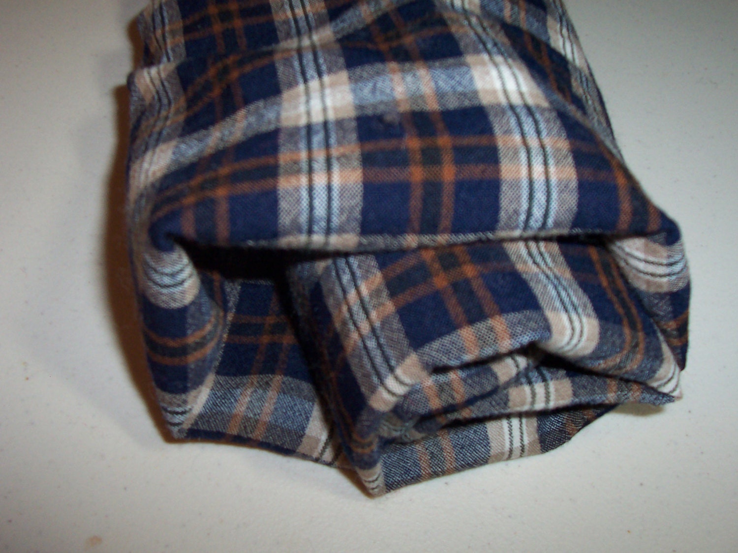 Plaid felted Pendleton shirt weight wool fabric in blues, tan, brown and black.