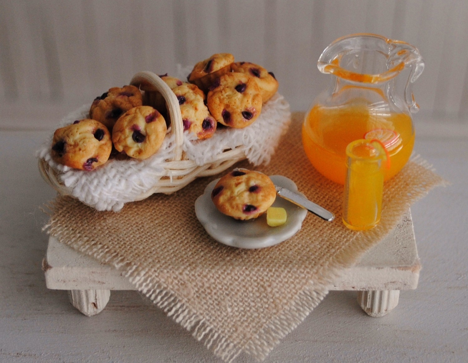Miniature Basket Of Blueberry Muffins, A Pitcher Of Orange Juice, A Glass Of Juice, And A Shabby Chic Footed Tray