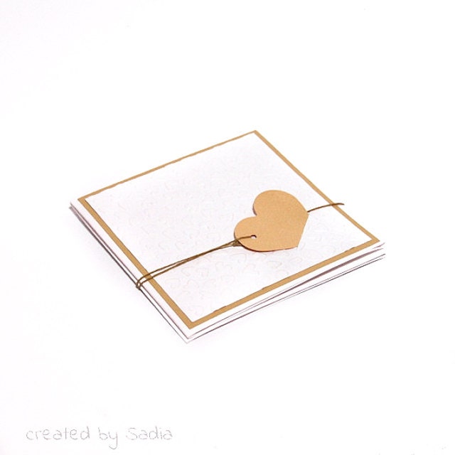 Handmade custom romantic folded wedding invitation, embossed background and beige heart.