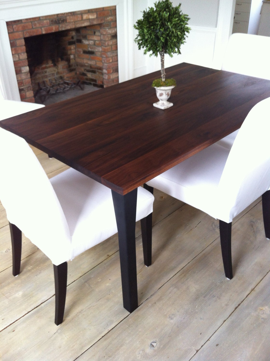 Modern industrial dining table featuring rustic black walnut top and steel legs.