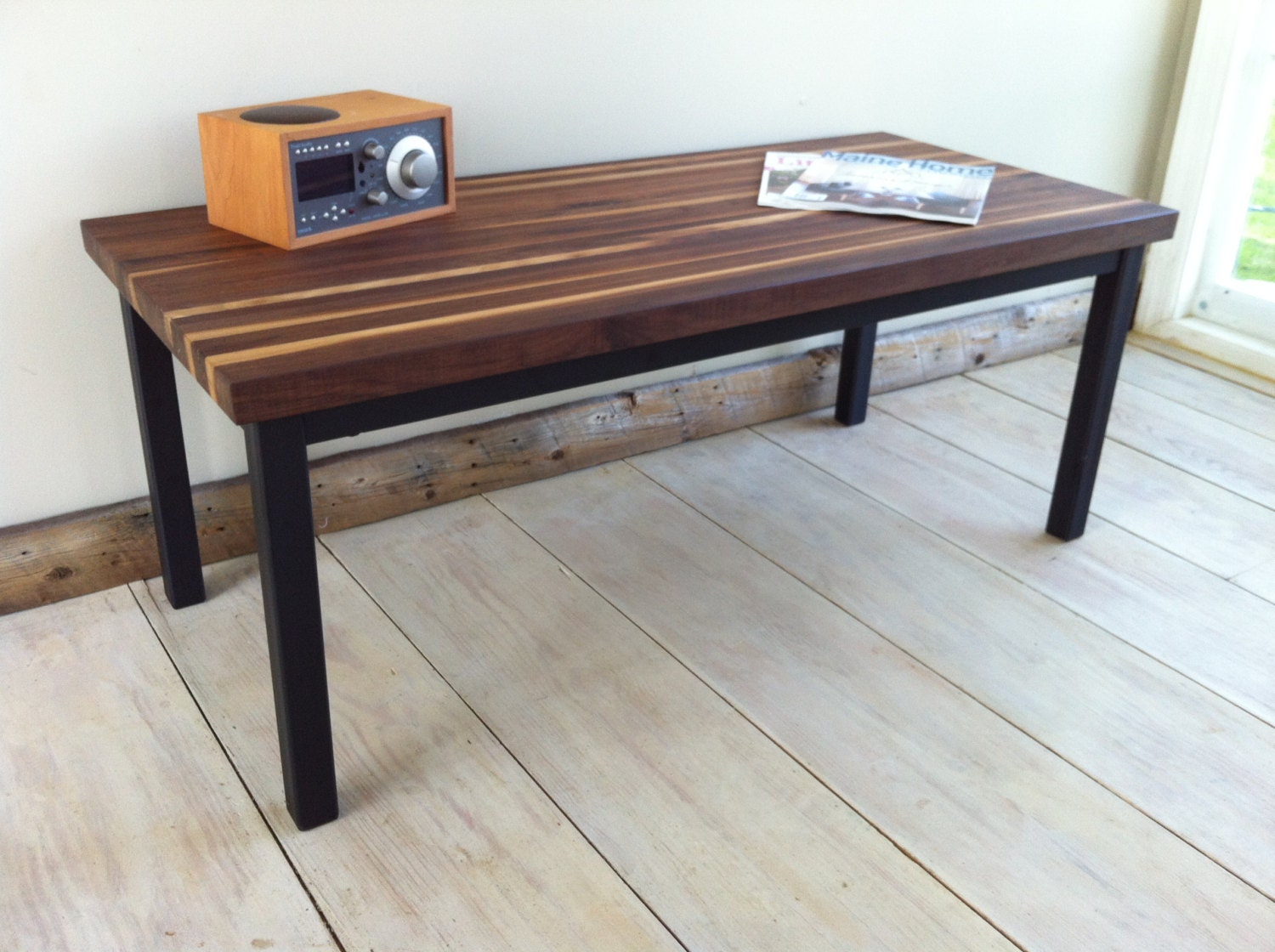 Modern industrial coffee table featuring walnut top and steel base, 20" x 44".