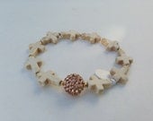 Cream cross bracelet with rhinestone beads