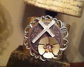 Metal cuff bracelet with metal clock face, metal flower and rhinestone cross