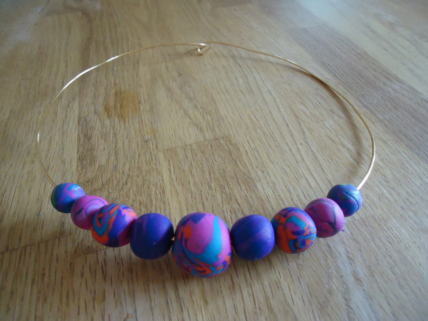 Multicoloured necklace, handmade beads in turquoise, purple, pink, red and blue made from polymer clay.