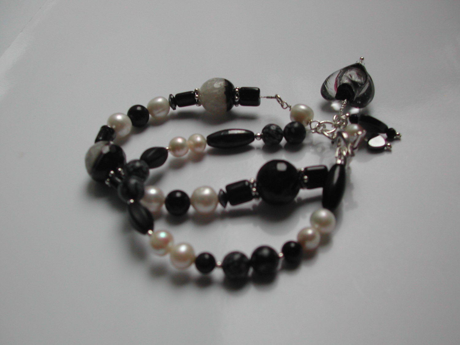 SALE   WAS 21.00   NOW 16.00    Double Strand Bracelet with Snow Agate, Snowflake Obsidian, Black Onyx and Freshwater Pearl.