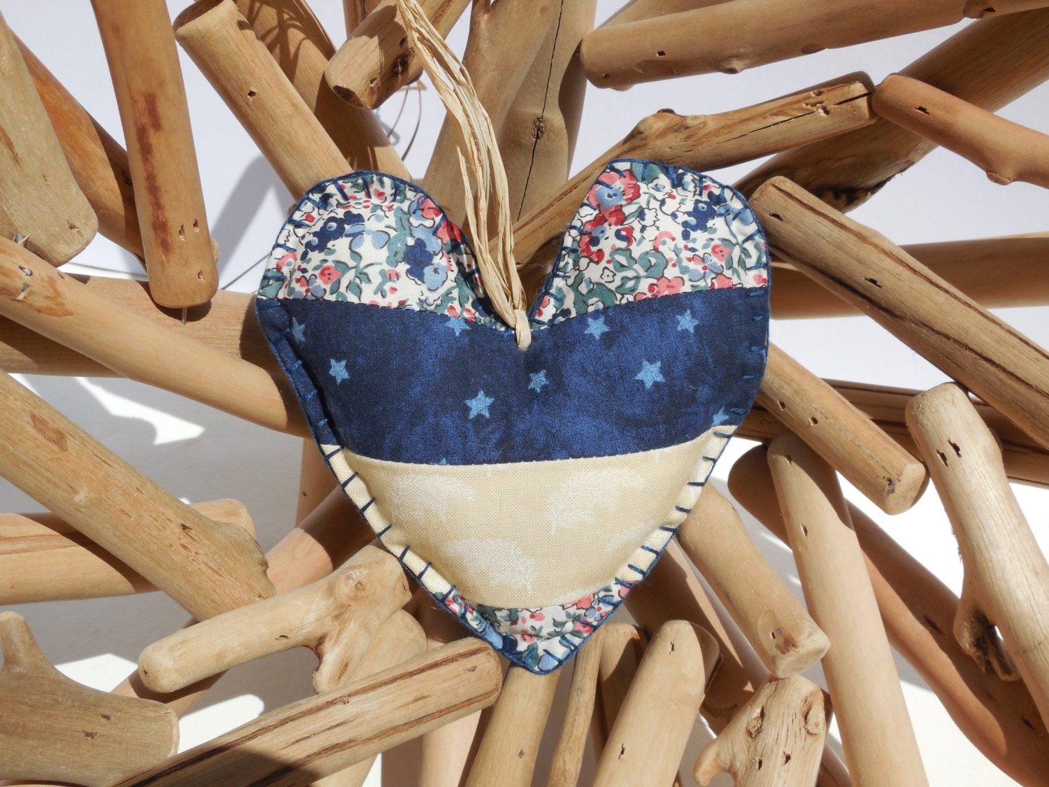A handmade patchwork shaped heart ornament in blue and cream