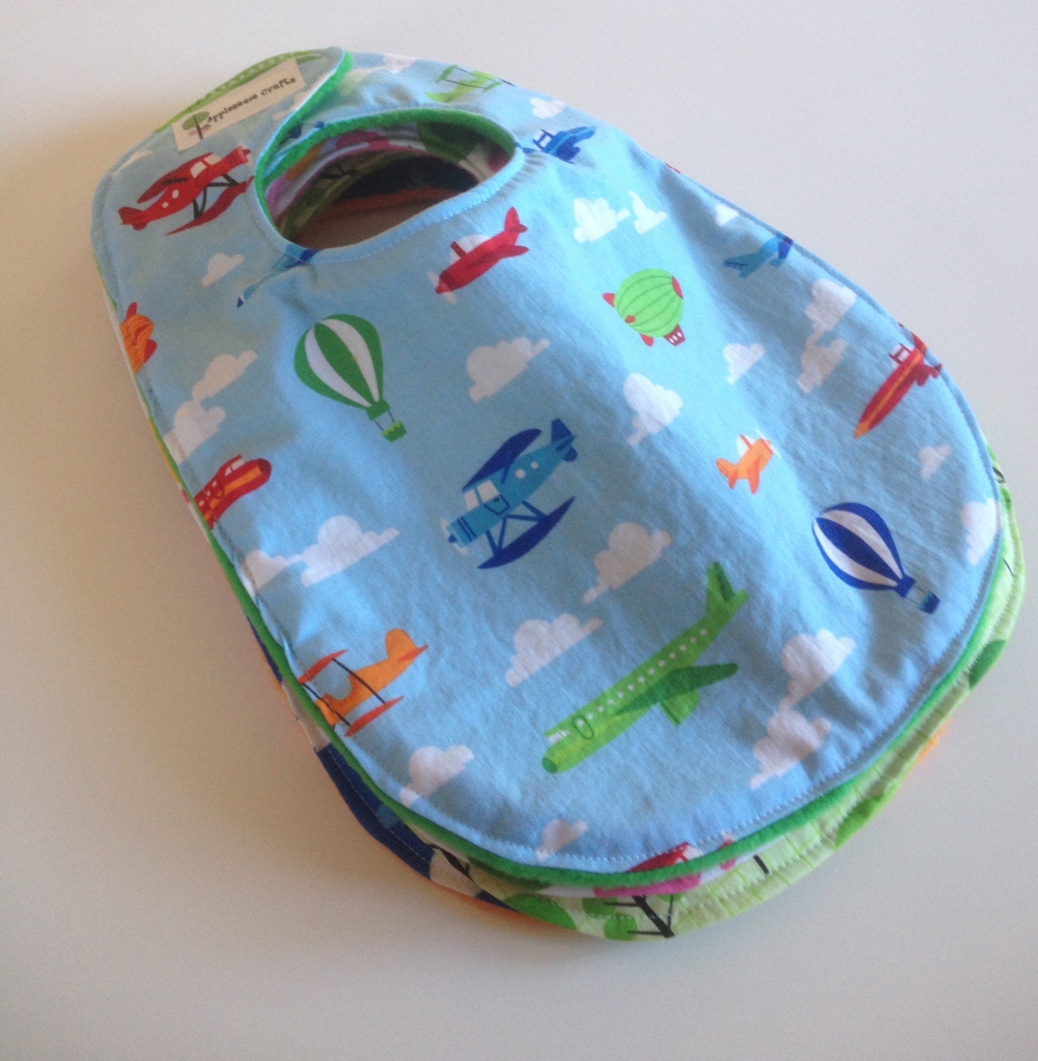 Large Bib in Pale Blue with Airplanes Hot Air Balloons Blimps with Green Fleece Backing
