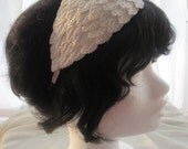 Vintage look wedding fascinator with white leaves.
