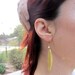 Gold feather long earring with tiny pearl.