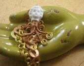 Disengaged antique Frozen Charlotte with copper and brass necklace