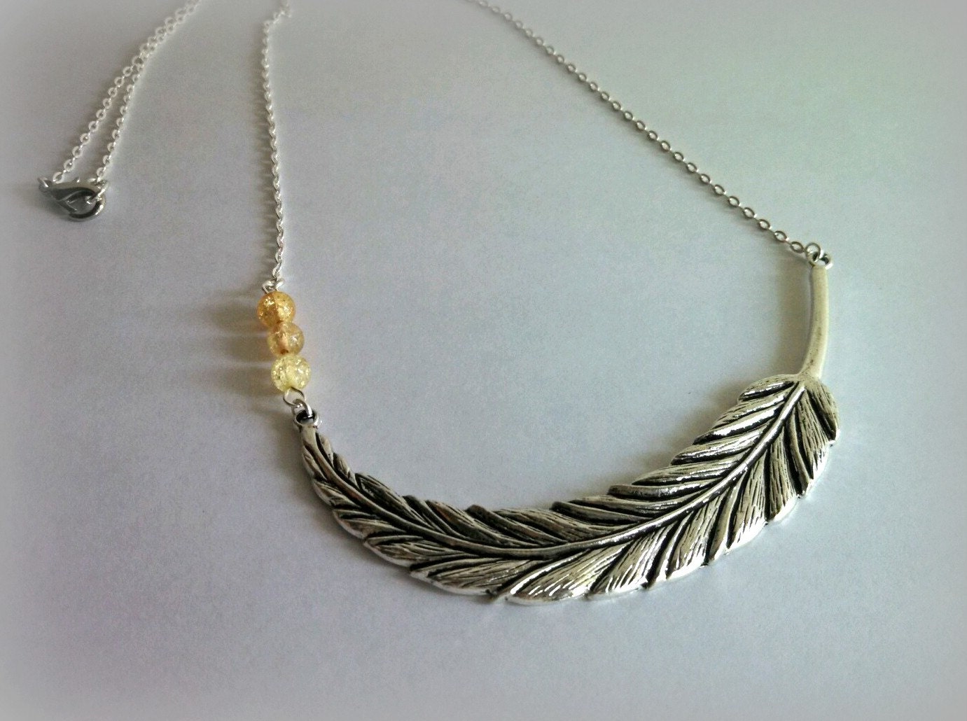 Feather pendant necklace, yellow accent beads, silver, boho chic, nature inspired