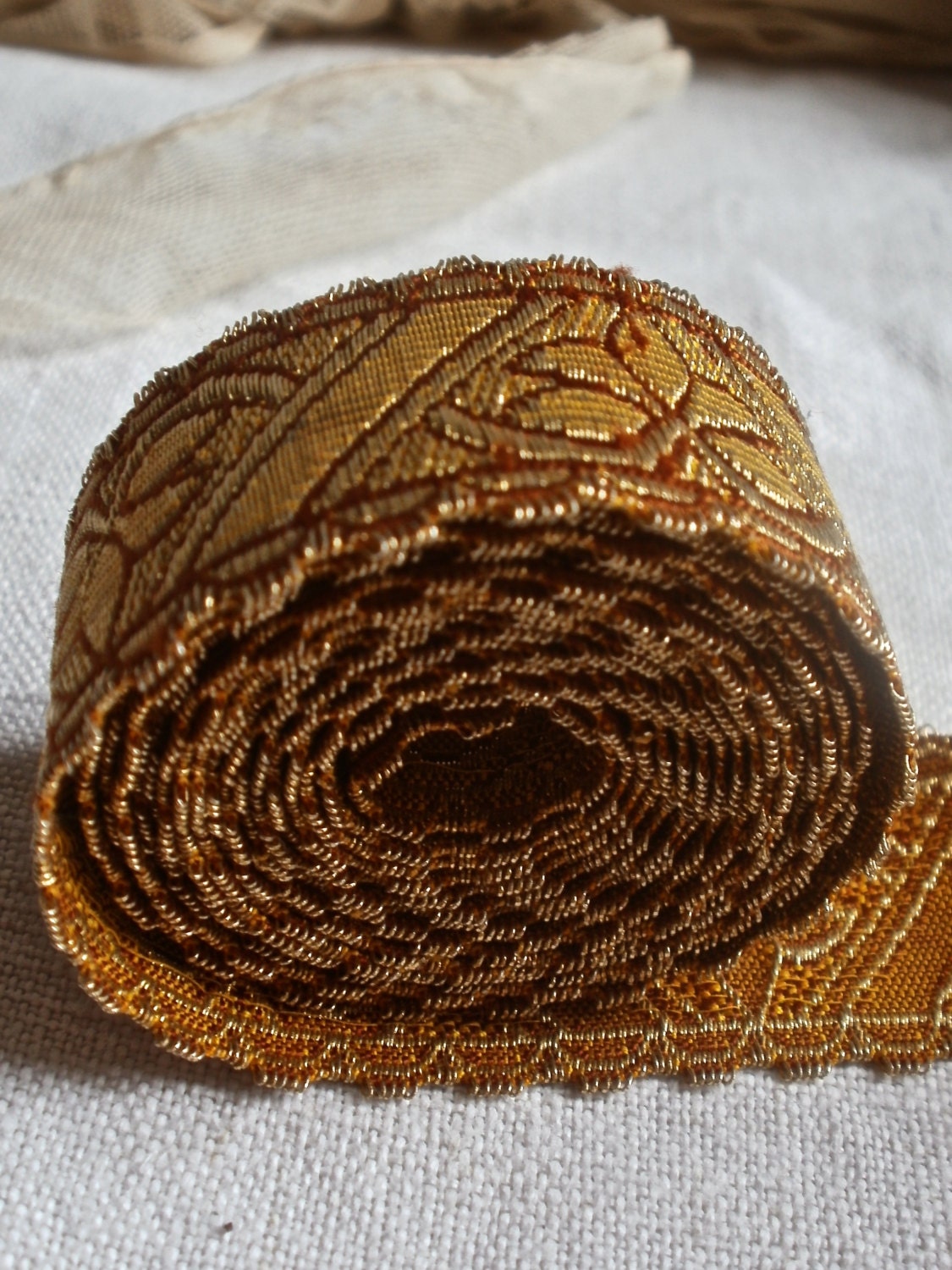 Metallic woven tape geometric design with flower golden and red Pre Raphaelite highly stylized