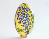 Wisteria on yellow background . Goose egg. Pysanka.