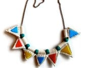 Embroidered jewelry necklace with colorful triangles strung on silver ball chain with turquoise beads
