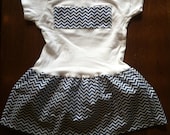 White and denim/chambray colored small chevron pattern skirted onesie