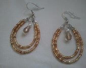 seed bead hoop earrings with champagne silver teardrop crystal beads dangling in middle