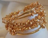 bb851 - Gold Finished tube beads, glass, metallic shiny gold, long magatamas, bead dangles at ends, memory wire bracelet