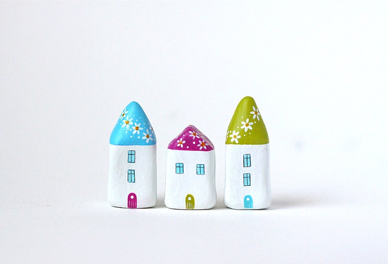 Little village with three clay houses with flowers