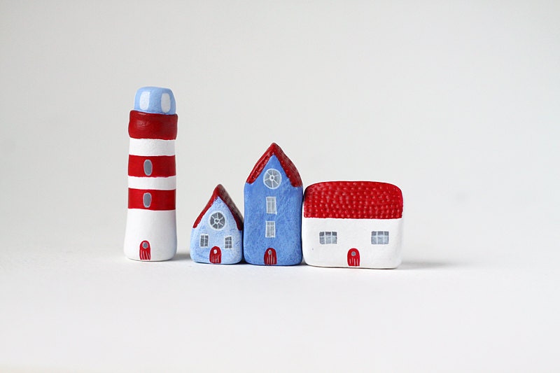 Three little clay houses and a striped lighthouse - blue, white and red