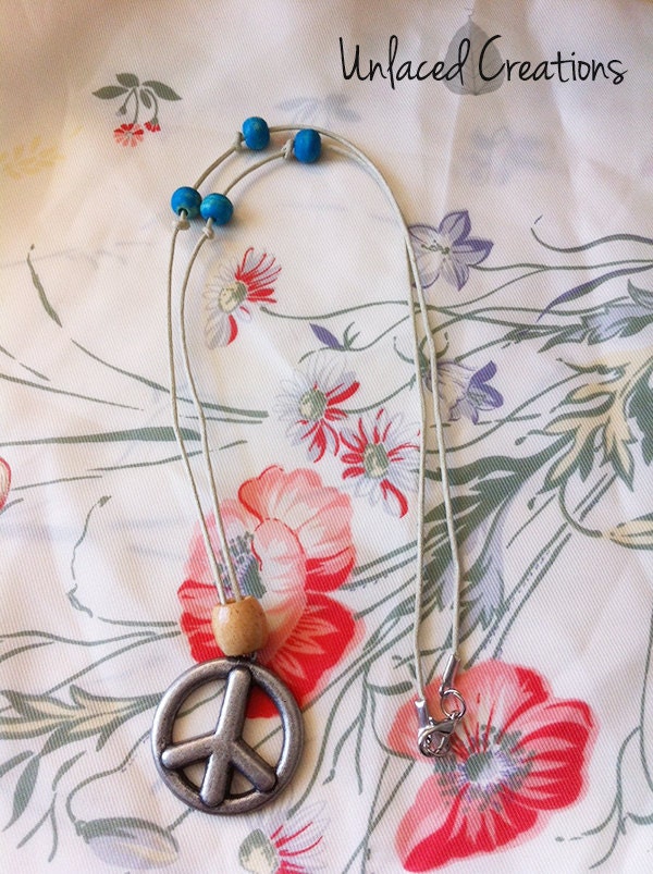 roxy. a peace sign necklace with wooden beads.