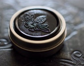 Figure 1: NOIR Solid Natural Perfume in Round Tin - Rain, moistened earth - Patchouli - Earthy, vegan musk. - IlluminatedPerfume