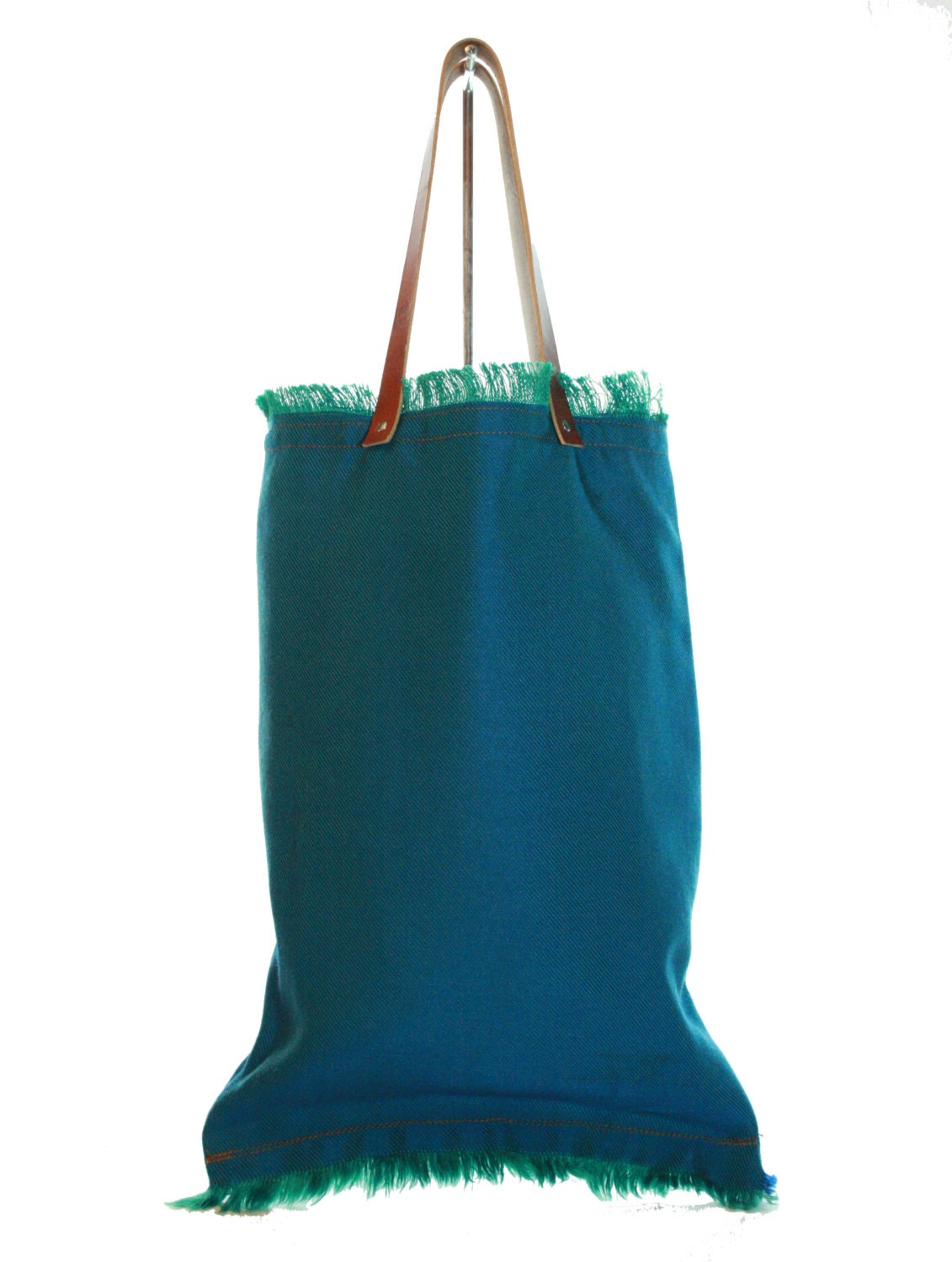 Cloth tote bag with leather handles. Lining in cotton with pocket.