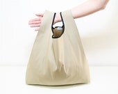Unisex shopping bag handmade with beige cotton tote bag edged in black ribbon and folding into a triangle elegant and minimal style - AtelierSettembre Unisex shopping bag handmade with beige cotton tote bag edged in black ribbon and folding into a triangle elegant and minimal style - AtelierSettembre