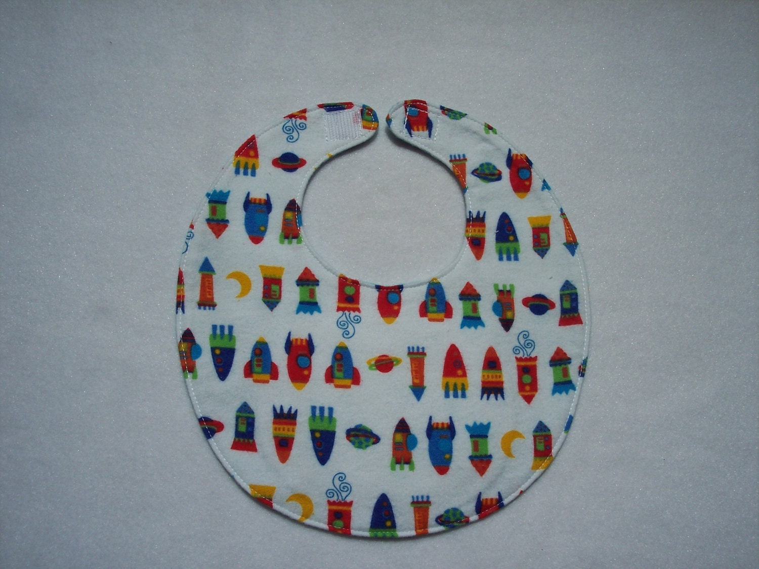 Baby bib, four soft layers, reversible, white with colorful space ships