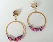 Gold hoop earring with pink and purple crystals and glass seed beads and a beautiful matte gold open work ear pad