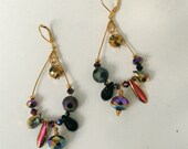 Gold tone elongated hoop earrings with multi color crystals and glass beads