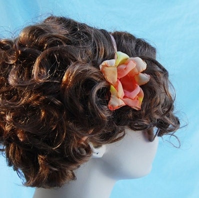 Handmade tropical fabric flower orange, yellows and reds with beaded center on light peach elastic headband. perfect holiday gift
