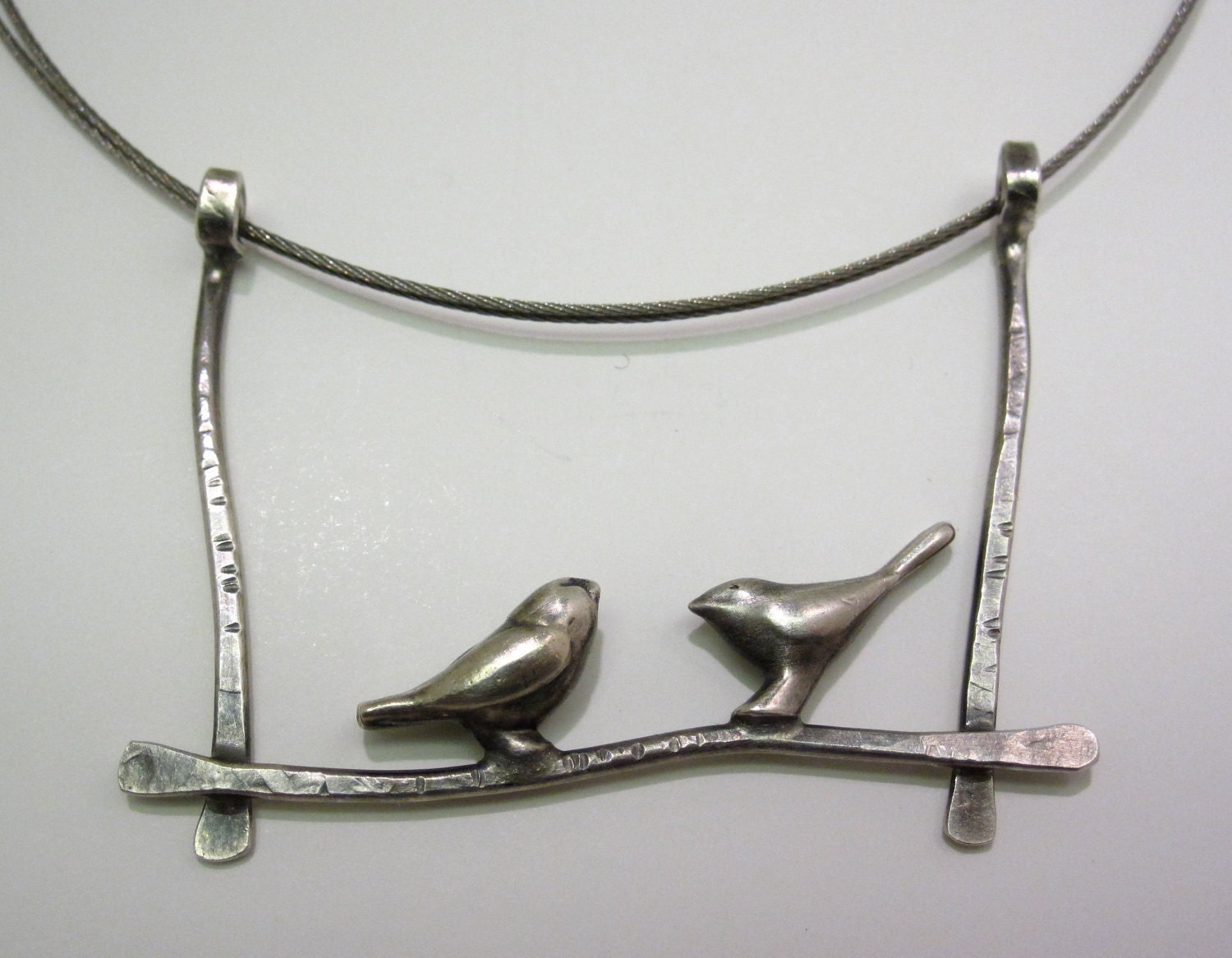 Two Silver Birds Perched on a Wire